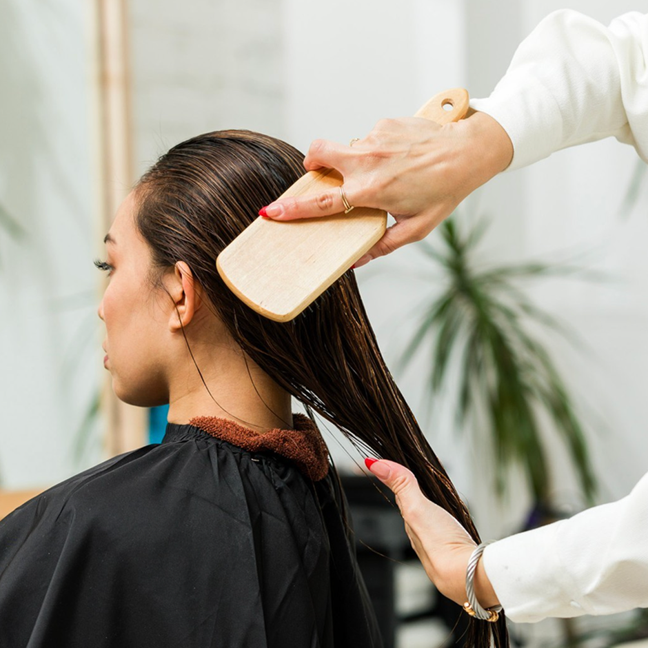 Hair stylist brushing hair with Paddle Brush