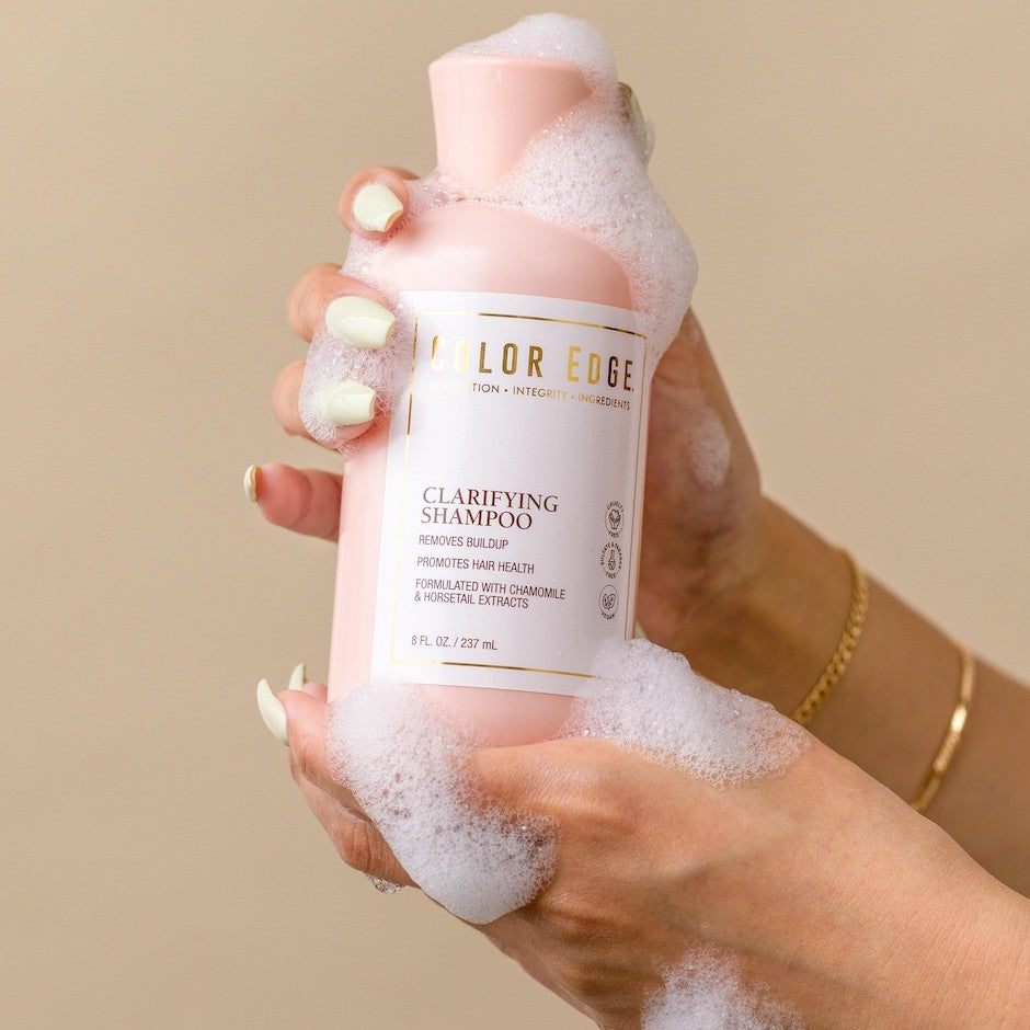 Clarifying Shampoo bottle in hand, soapy.