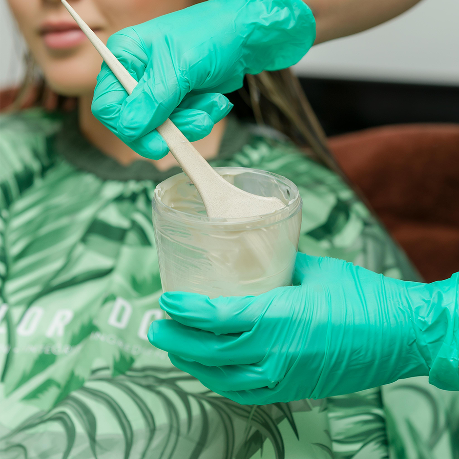 Stylist scooping out hair color from Color Shaker