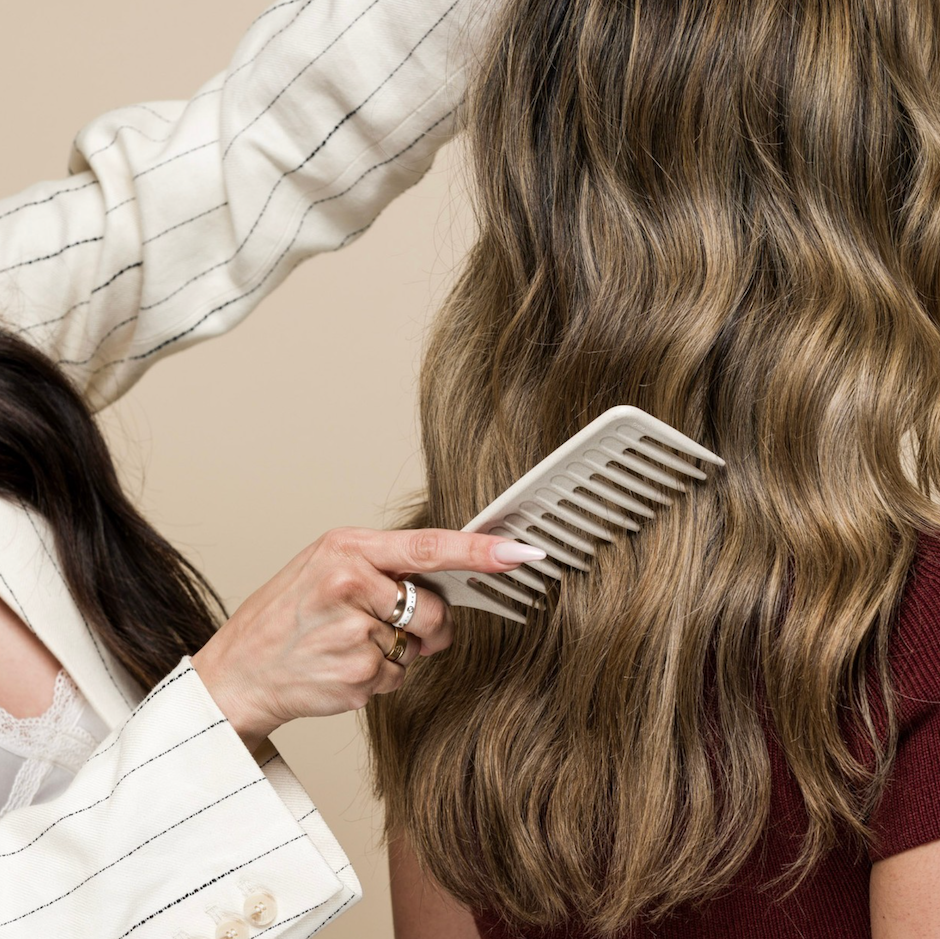 Hair stylist brushing hair with Wide Tooth Comb