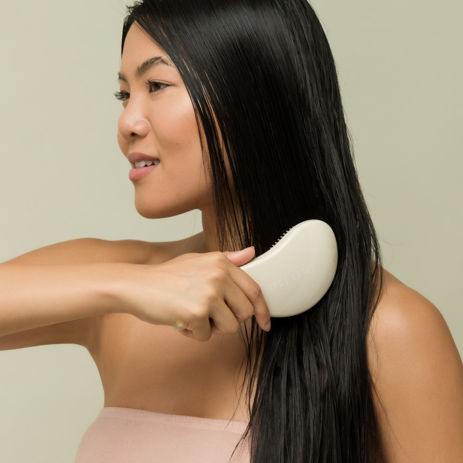 Woman brushing hair with Detangle Brush