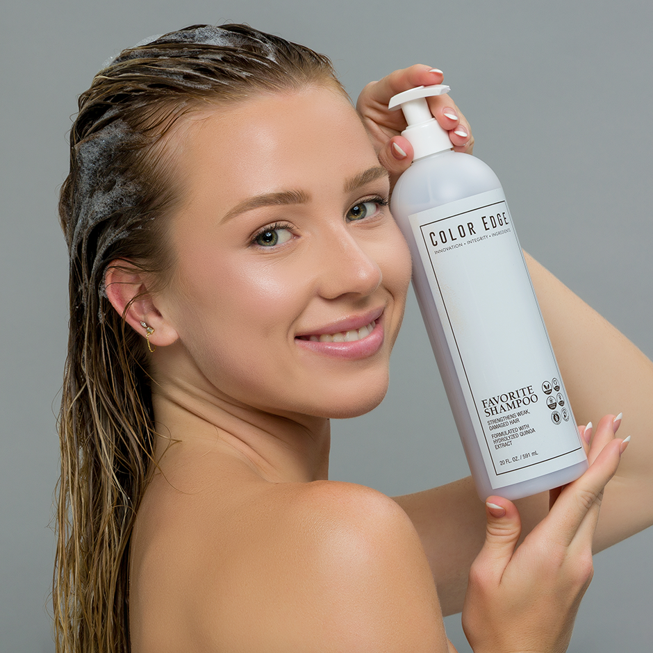 Woman with shampoo on her hair holding a bottle of 'Color Edge' Favorite Shampoo